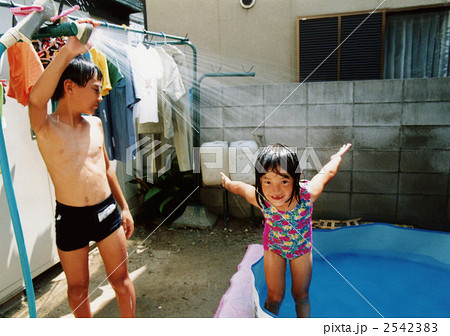 女の子 子供 兄妹 水浴びの写真素材