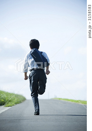 高校生 後姿 一本道 制服の写真素材