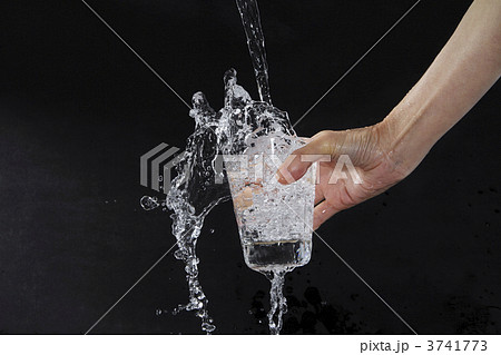 水 こぼれる 手 グラスの写真素材