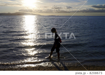 女の子 夕日 陰 逆光の写真素材