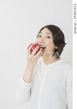 女性 かじる 食べる りんごの写真素材