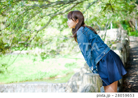 女性 ミニスカート 笑顔 座る 学生 日本人 大学生の写真素材