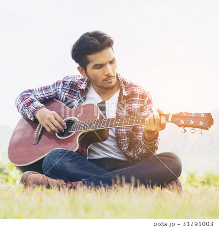 ギター 演奏 座る シャツの写真素材