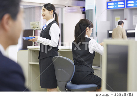 銀行窓口 女性銀行員 女性行員 後ろ姿の写真素材