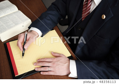 リーガルパッドにメモをする男性弁護士の手元 バッジありの写真素材 48356113 Pixta