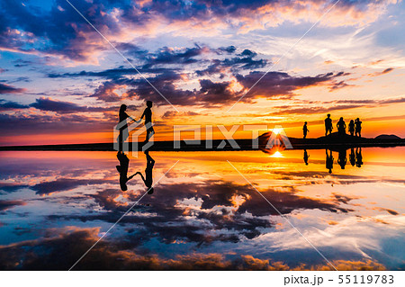 海 カップル シルエット 夕焼けの写真素材