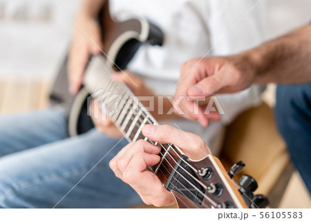 ギター 演奏 座る シャツの写真素材