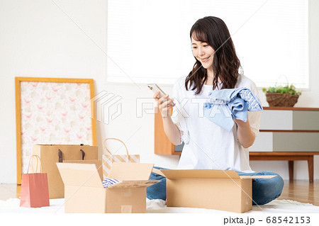 スマホでネットショッピング　開封する若い女性