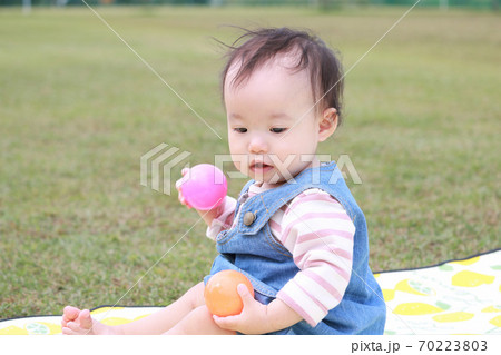 女の子 子供 ジャンパースカート 芝生の写真素材