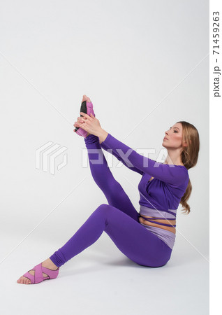 Beautiful Woman in Purple Leggings and Top Posing on a White