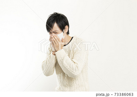 マスク姿の男性/頭痛で頭を抱える/具合が悪い独身男性/	