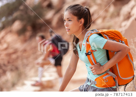 Happy young Asian hiker girl hiking with friend in mountain nature