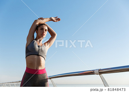 Side view of attractive and healthy fitness woman running along