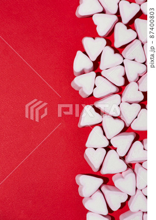 Waffle cone with heart-shaped marshmallows, close-up on a blue