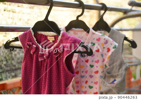 Young woman hangs clothes on clothesline outdoors in the courtyard