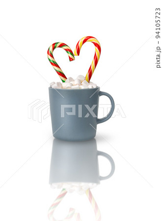 White and pink heart-shaped marshmallows are scattered from a cup