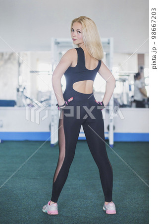 slim athletic woman working out with battle rope in gym. fitness