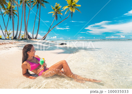 Beautiful Asian fit bikini body model relaxing on Caribbean beach